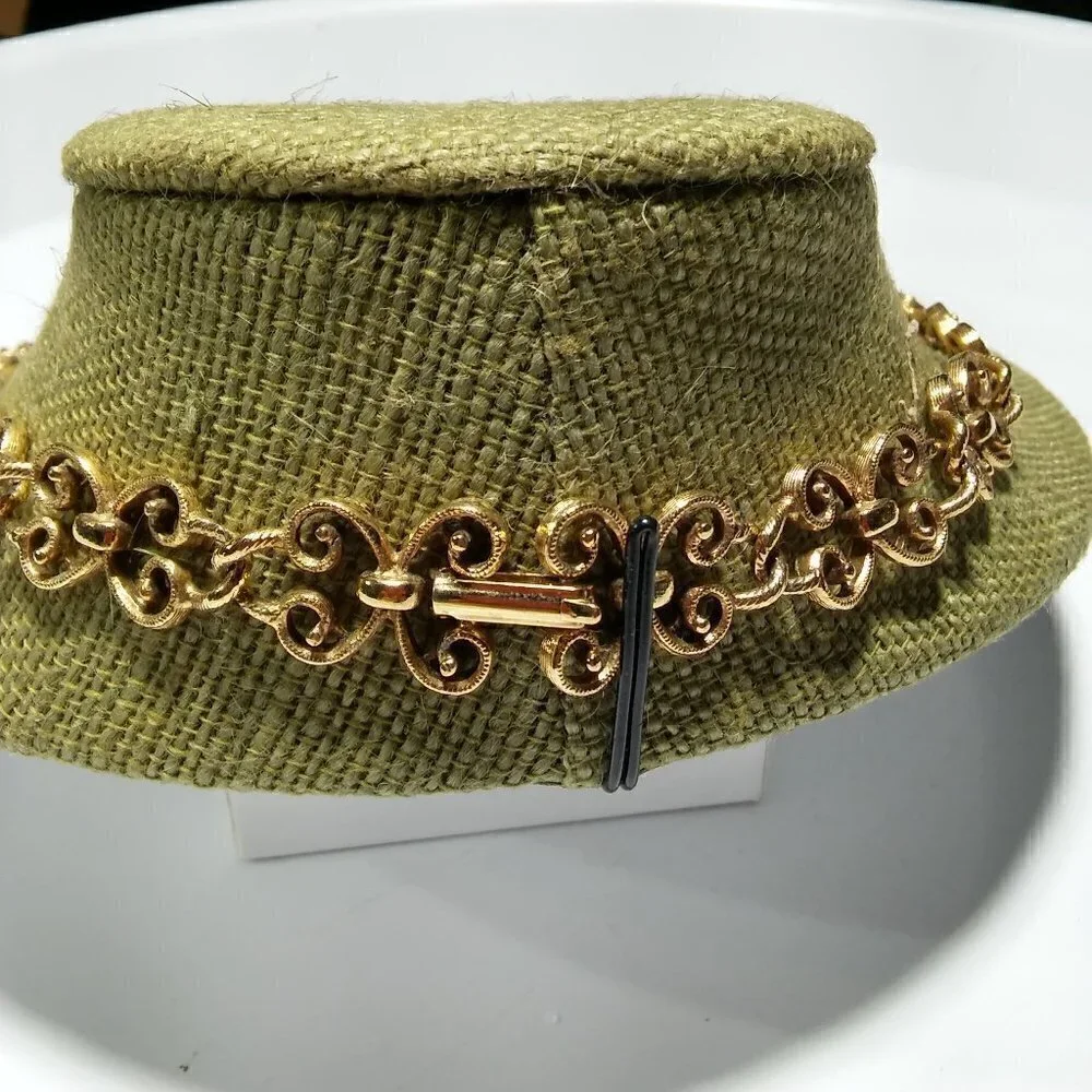 Women`s gold tone swirl necklace. 19 inches long.
